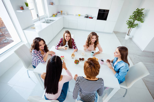 Close up top above high angle view photo beautiful she her ladies group best friends sit round big white table bright kitchen hold cups listen rumours news having fun girls day night holiday indoors - Фото, зображення