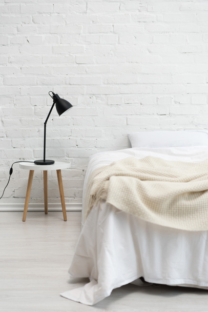 bedroom with empty white bed and lamp on stool - Foto, Bild