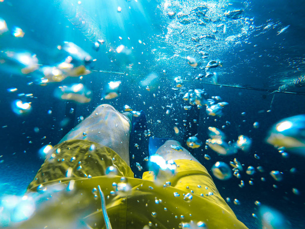 man onderwater zwemmen in zwembad met flippers - Foto, afbeelding