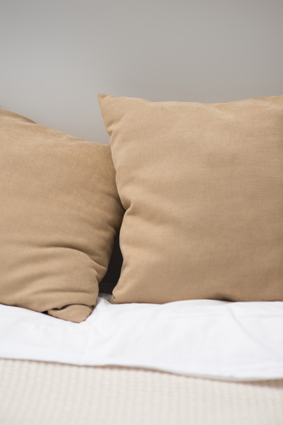 Close up de travesseiros marrons na cama acolhedora
  - Foto, Imagem