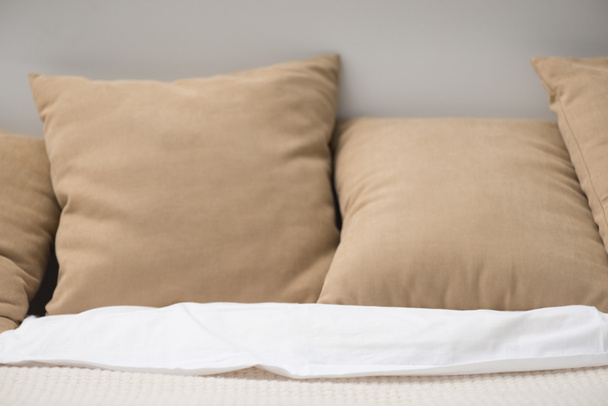 Close up van bruin kussens op gezellige lege bed  - Foto, afbeelding