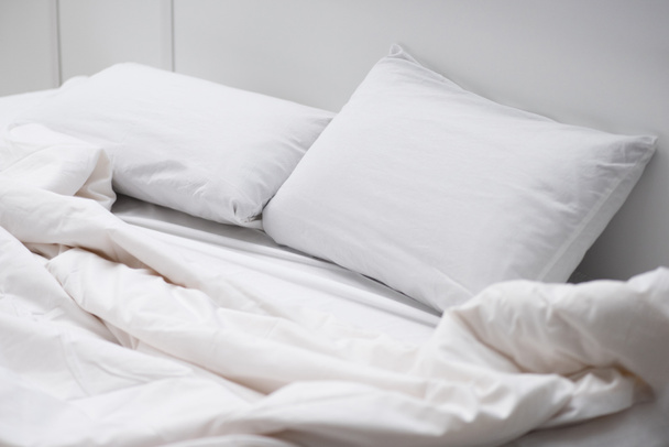 lit vide avec oreillers blancs et couverture
  - Photo, image