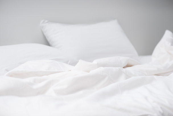 enfoque selectivo de la cama acogedora vacía con almohadas blancas y manta
  - Foto, Imagen