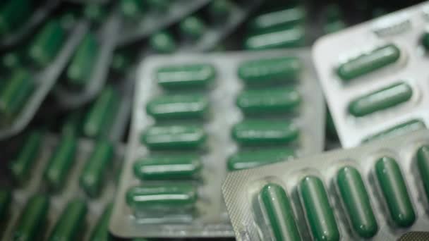 Cápsulas verdes caídas en blíster. Fabricación de medicamentos, macro
 - Metraje, vídeo