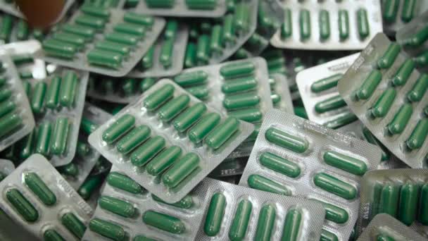 Egy kéz véghezvinni zöld tablettát kapszula buborékfóliában - Felvétel, videó