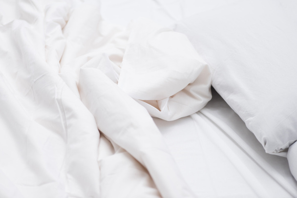Close up of bed with white sheets and blanket  - Foto, afbeelding