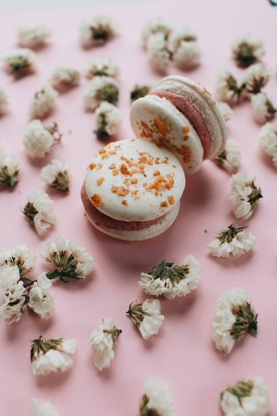 composition of two delicious macaroons and floral petals  - Foto, afbeelding