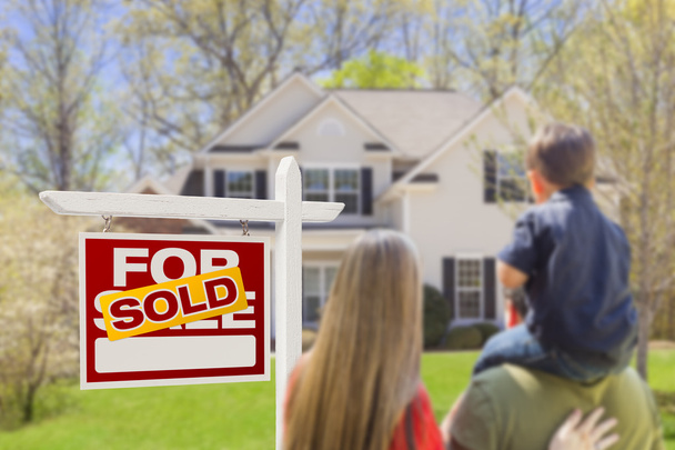 Família enfrentando Vendido para venda Imobiliária sinal e casa
 - Foto, Imagem