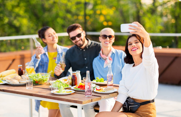 happy friends taking selfie at rooftop party - Photo, Image