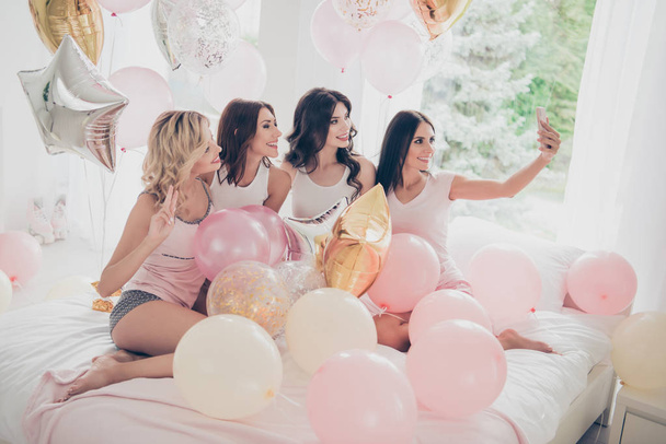 Portrait of nice cute lovely winsome attractive charming cheerful glad girlfriends making taking selfie showing v-sign having fun in light white interior decorated house indoors - Zdjęcie, obraz