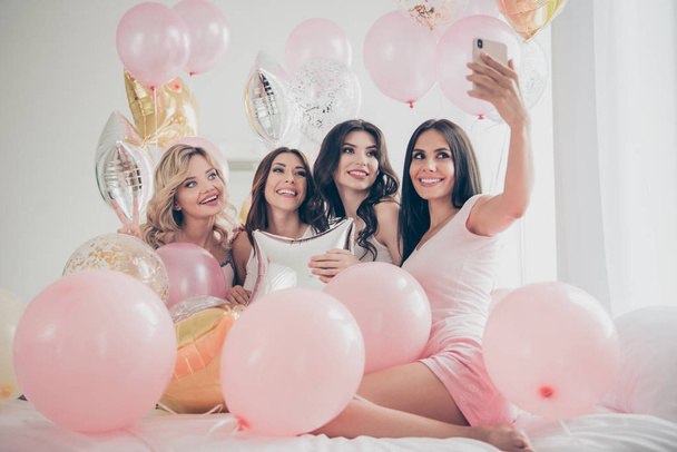 Portrait of nice cute lovely attractive charming cheerful glad girlfriends making taking selfie hugging baloon having fun in light white interior decorated house indoors - Foto, Bild