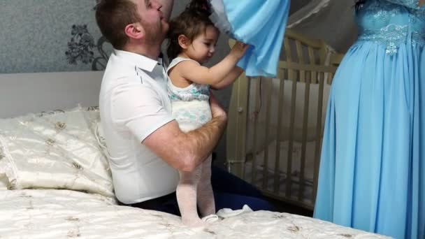 Rodiče rádi oblékají jejich malá dcera v šatech - Záběry, video