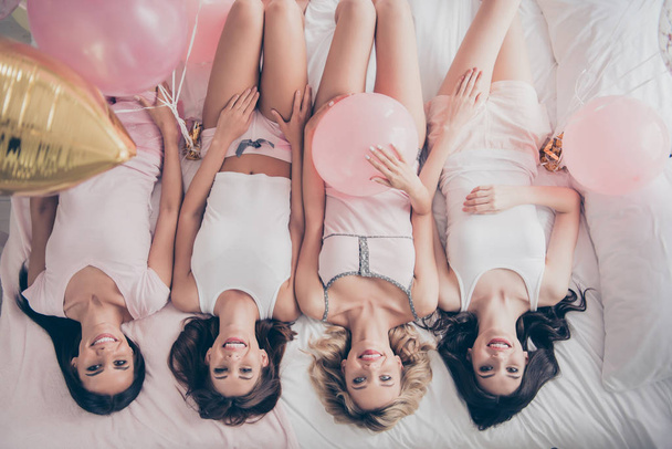 Top above high angle view of four person nice cute lovely attractive charming cheerful slim girlfriends having fun lying on bed in light white interior decorated house indoors - Valokuva, kuva