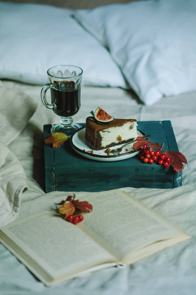 Desayuno en la cama con pastel de queso con café y chocolate
 - Foto, Imagen