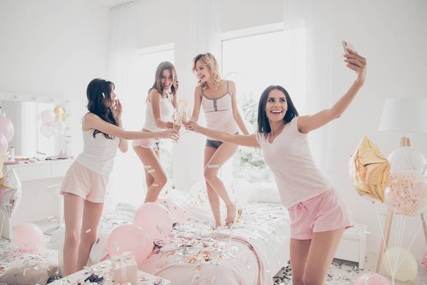Nice sweet lovely fascinating cool attractive feminine charming fit thin slim graceful cheerful cheery girlfriends having fun making taking selfie in light white interior decorated house - Foto, afbeelding