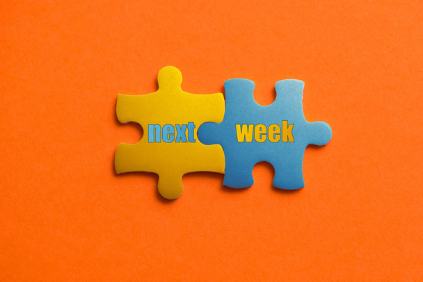 Dos detalles de color del rompecabezas con texto La próxima semana sobre fondo naranja, Amarillo y Azul, de cerca
. - Foto, Imagen