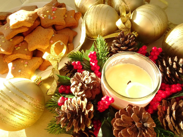 Vela de Navidad, galletas de jengibre y bolas de oro
 - Foto, imagen