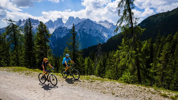 Cyclisme touristique à Cortina d'Ampezzo, superbes montagnes rocheuses en arrière-plan. Randonnée en famille VTT enduro flow trail. Tyrol du Sud province d'Italie, Dolomites
. - Photo, image