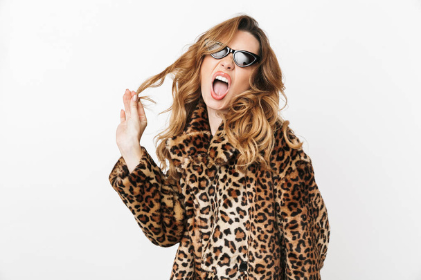 Beautiful young woman wearing leopard coat standing isolated over white background, posing - Foto, Imagen