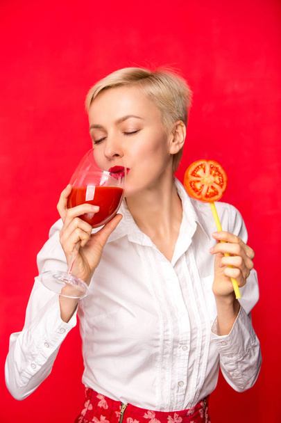 žena s sklenice červené rajčatové šťávy. Koncept zdravého životního stylu - Fotografie, Obrázek