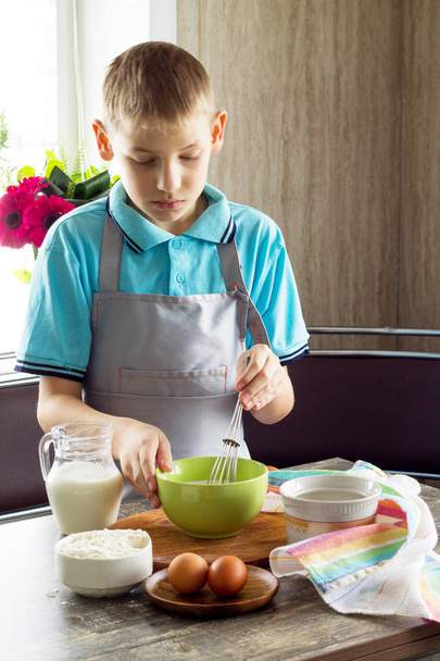 Смешной счастливый повар, готовящий на кухонном столе и готовящий тесто. Питание для детей
 - Фото, изображение