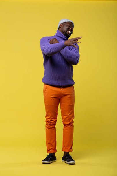 Emotional international man standing over yellow background - Valokuva, kuva