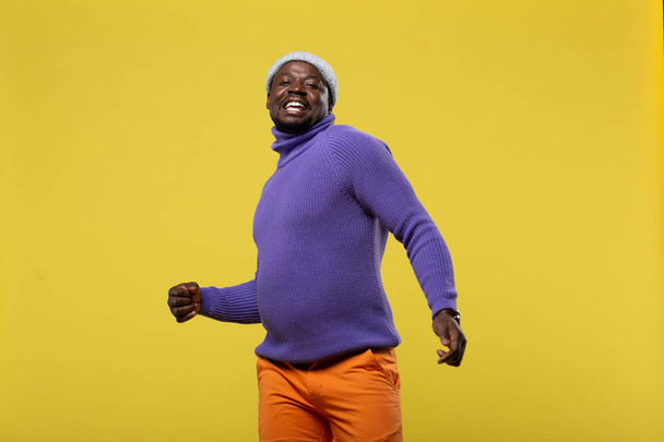 Positive delighted man posing over yellow background - Fotó, kép