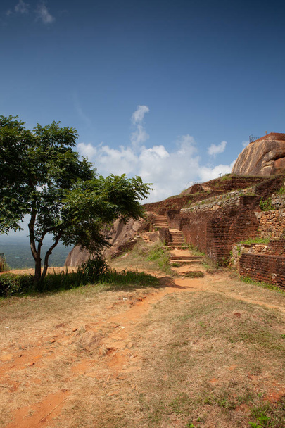 Ruins on top of Sigiriya Lion's rock palace and fortress.Sri Lanka. The name refers to a site of historical and archaeological significance that is dominated by a massive column of rock nearly 200 metres high. - Photo, image