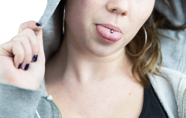 Giovane teen ragazza con piercing lingua e felpa con cappuccio - Foto, immagini