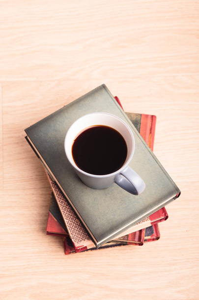Alcuni libri con tazza di caffè sul pavimento in legno
 - Foto, immagini