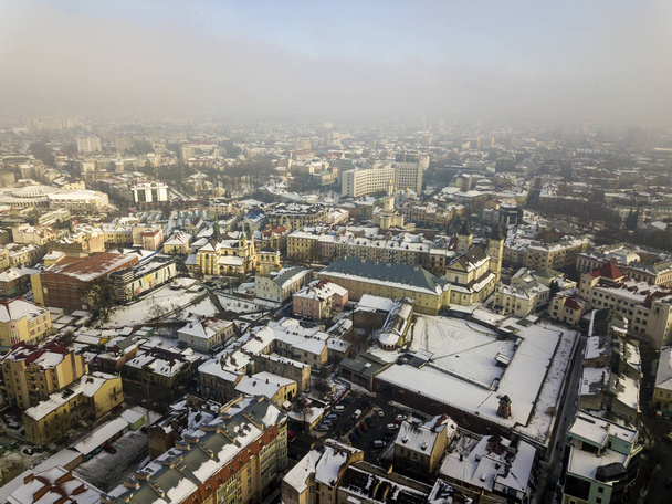 Antenni musta ja valkoinen talvi ylhäältä näkymä modernin kaupungin keskustaan korkeat rakennukset ja pysäköity autoja luminen kaduilla. - Valokuva, kuva