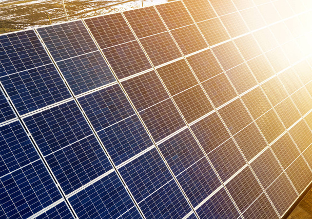 Superfície de close-up de iluminado pelo sol azul brilhante painéis solares fotovoltaicos. Sistema de produção de energia limpa renovável. Conceito de produção de energia verde ecológica renovável
. - Foto, Imagem