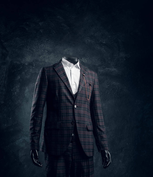 Male mannequin in exclusive custom made mens suit in a dark tailor studio  - Photo, Image