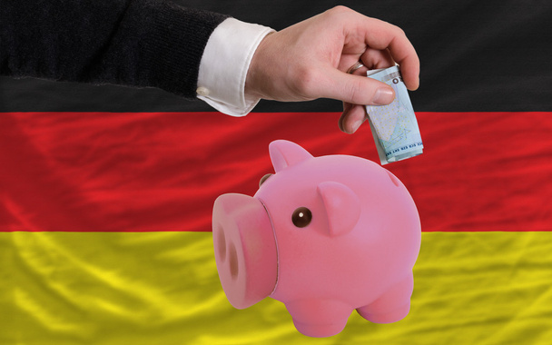 Financiación del euro en una alcancía rica Bandera nacional de Alemania
 - Foto, Imagen