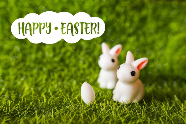 дві фігури кролика і яйце на траві. щасливого Великодня концепція
 - Фото, зображення