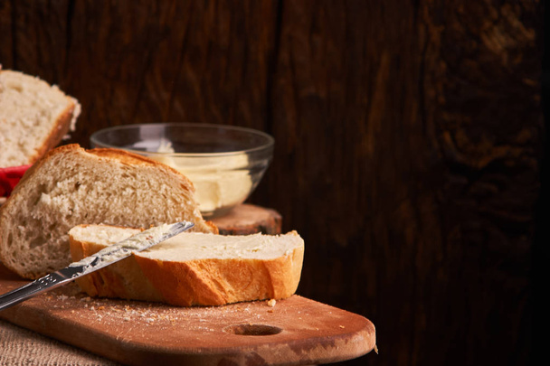 Panadería - pan crujiente rústico de oro y bollos sobre fondo de pizarra negro
 - Foto, imagen