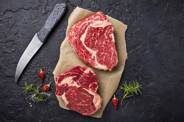 Raw marbled ribeye steak and spices - Foto, Imagem