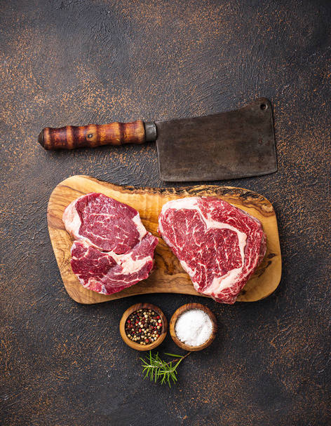 Raw marbled ribeye steak and butchers knife - Foto, Imagem