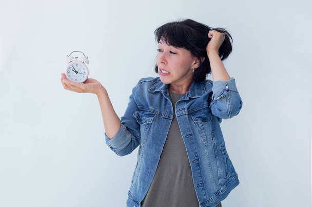 Beyaz bir arka plan üzerinde pembe bir çalar saat tutan Asyalı kadın. zaman yönetimi kavramı. hayatının kontrolünü almak - Fotoğraf, Görsel