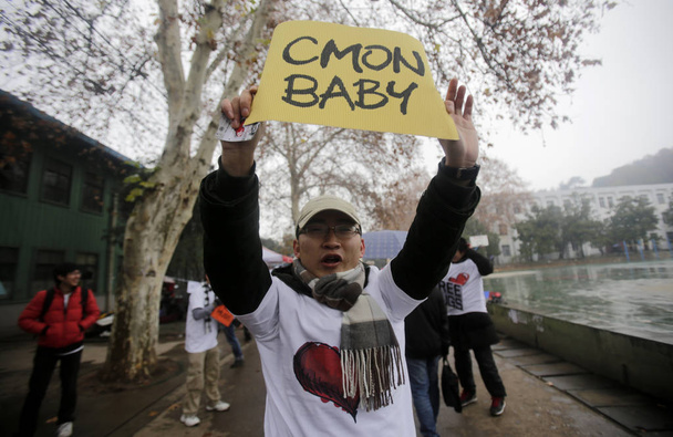 A young Chinese student holds up a sign saying, Come On Baby, during a free hug campaign to mark the end of the world from the Mayan apocalypse at Wuhan University in Wuhan city, central Chinas Hubei province, 20 December 2012 - Foto, Imagem