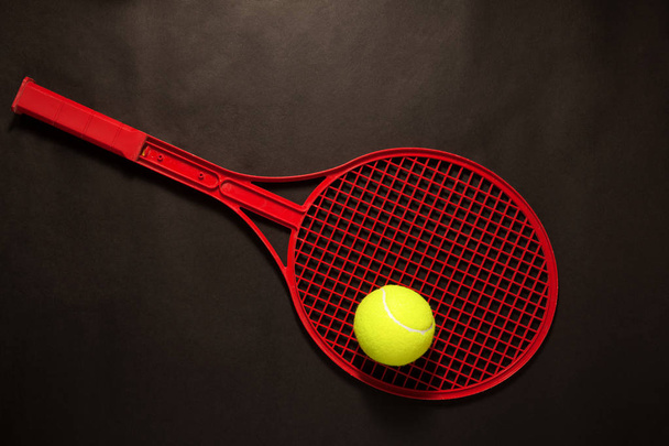 tennis ball and racket on dark background - Фото, изображение