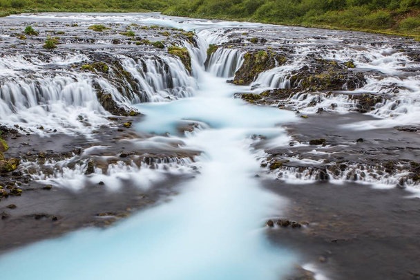 Detail of bright powerful Bruarfoss waterfall in Iceland with cyan water. - Photo, Image