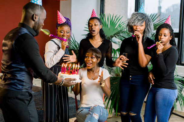 African Teenagers with party horns and a cake celebrating a birthday - Fotó, kép