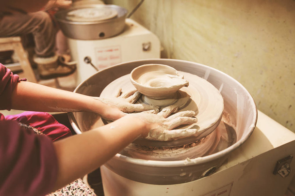 Le mani di bambino plasmano l'argilla su ruota di ceramica a officina
. - Foto, immagini