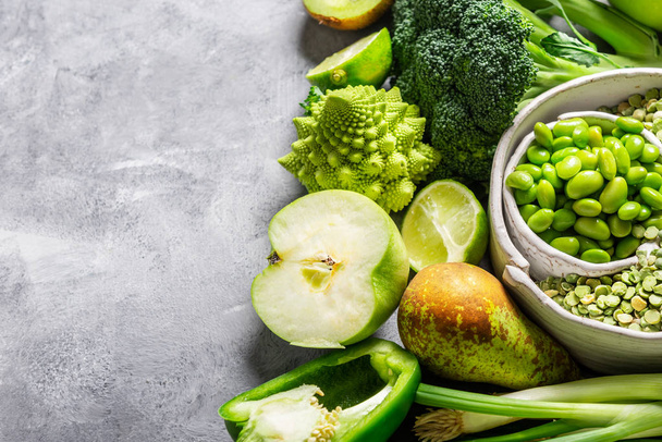 Erilaisia vihreitä vihanneksia ja hedelmiä harmaalla taustalla
 - Valokuva, kuva