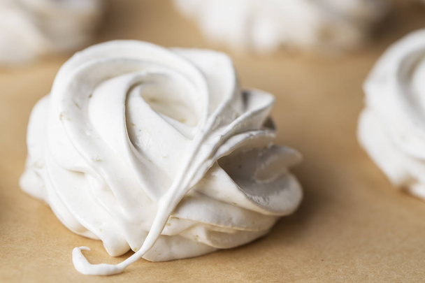 Proces tvorby marshmallow. Detailní záběr rukou šéfkuchaře cukrovinky sáček krémem na pergamen na pečivo obchod kuchyně - Fotografie, Obrázek