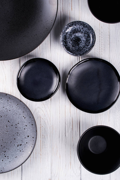 Sada porcelánu handcraft šedé a černé talíře a mísy na bílý dřevěný stůl. Rozložení bytu - Fotografie, Obrázek