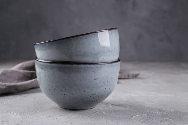 素朴なスタイルのスタックは、ぼろぼろの灰色の壁に対して中立的なトーンの鉢を手作り。シンプルな食器 - 写真・画像