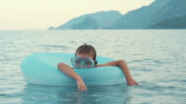 Little boy sleeping on rubber ring swimming in sea. Child relaxing at sea - Footage, Video