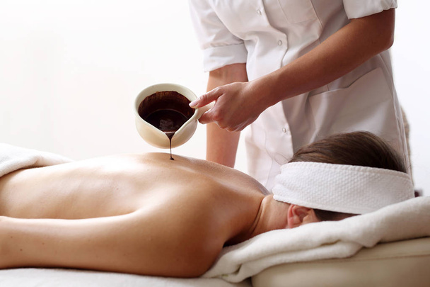 Massage mit Schokolade. Entspannung für den Körper im Wellnessbereich. - Foto, Bild